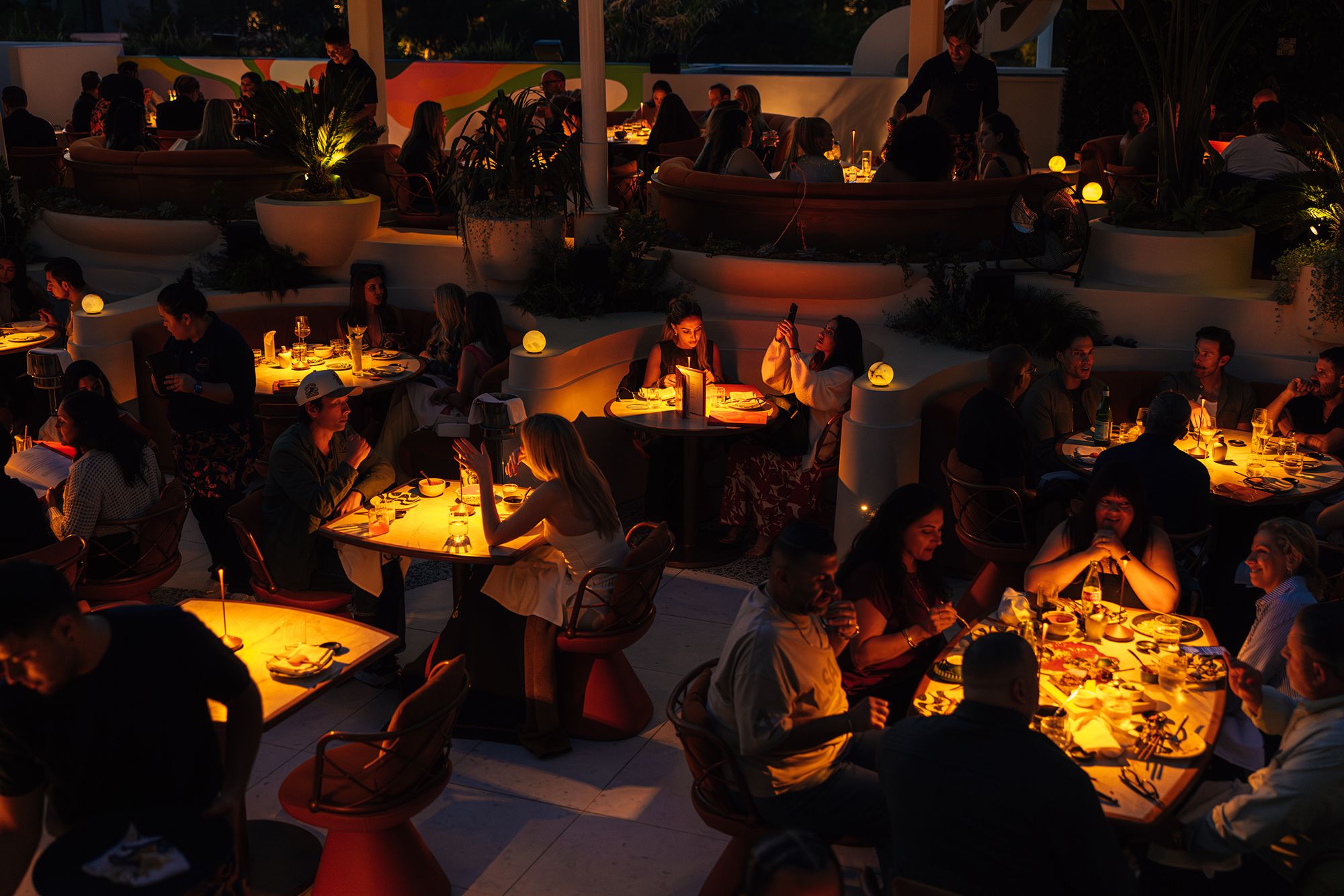 SUSHISAMBA Los Angeles dining room at night, with lit tables and guests dining